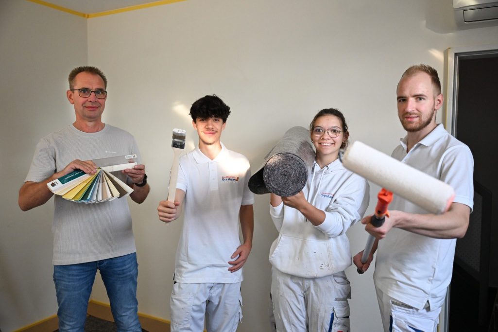 © Andreas Buck Vier Mitarbeiter mit Malerwerkzeugen in den Händen