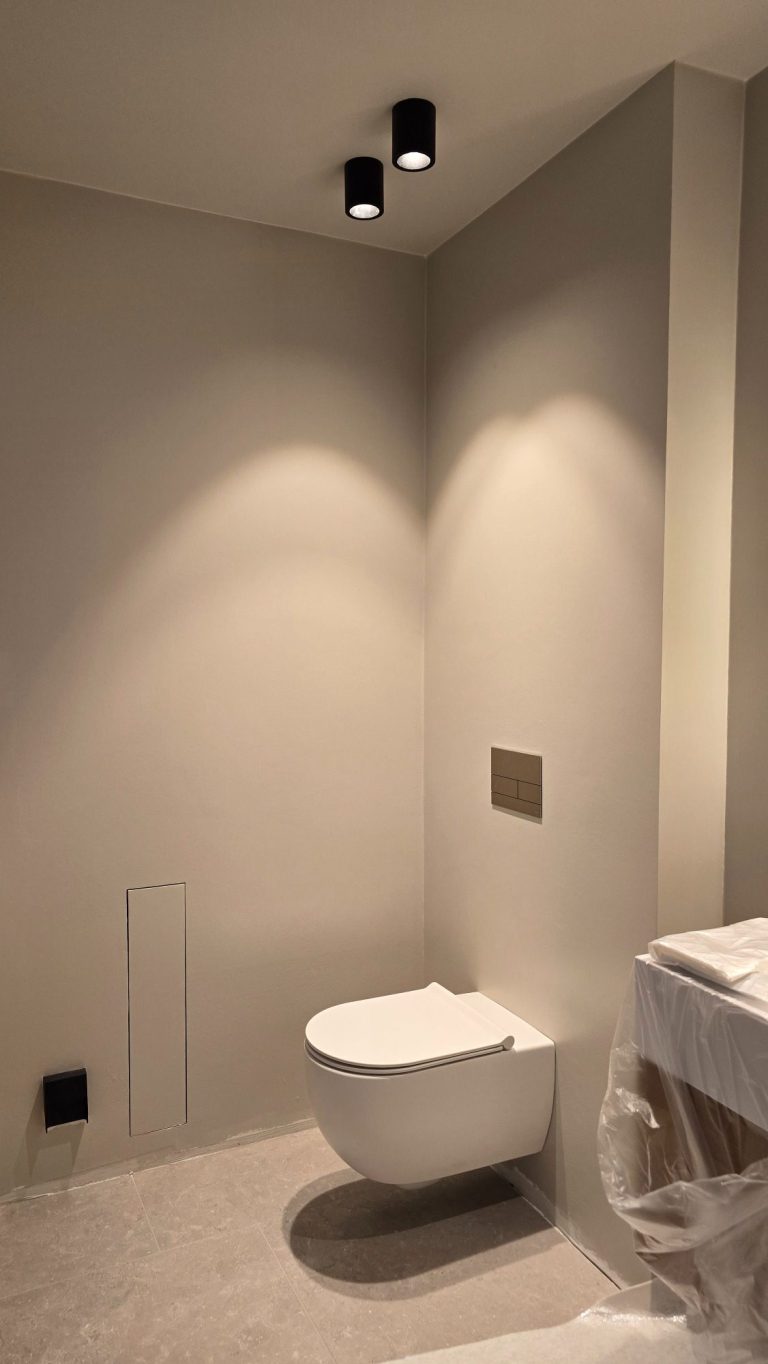 Badezimmer. Wände vollflächig gespachtelt und mit Malerglattvlies tapeziert. Anstrich seidenmatt, leicht grau getönt.